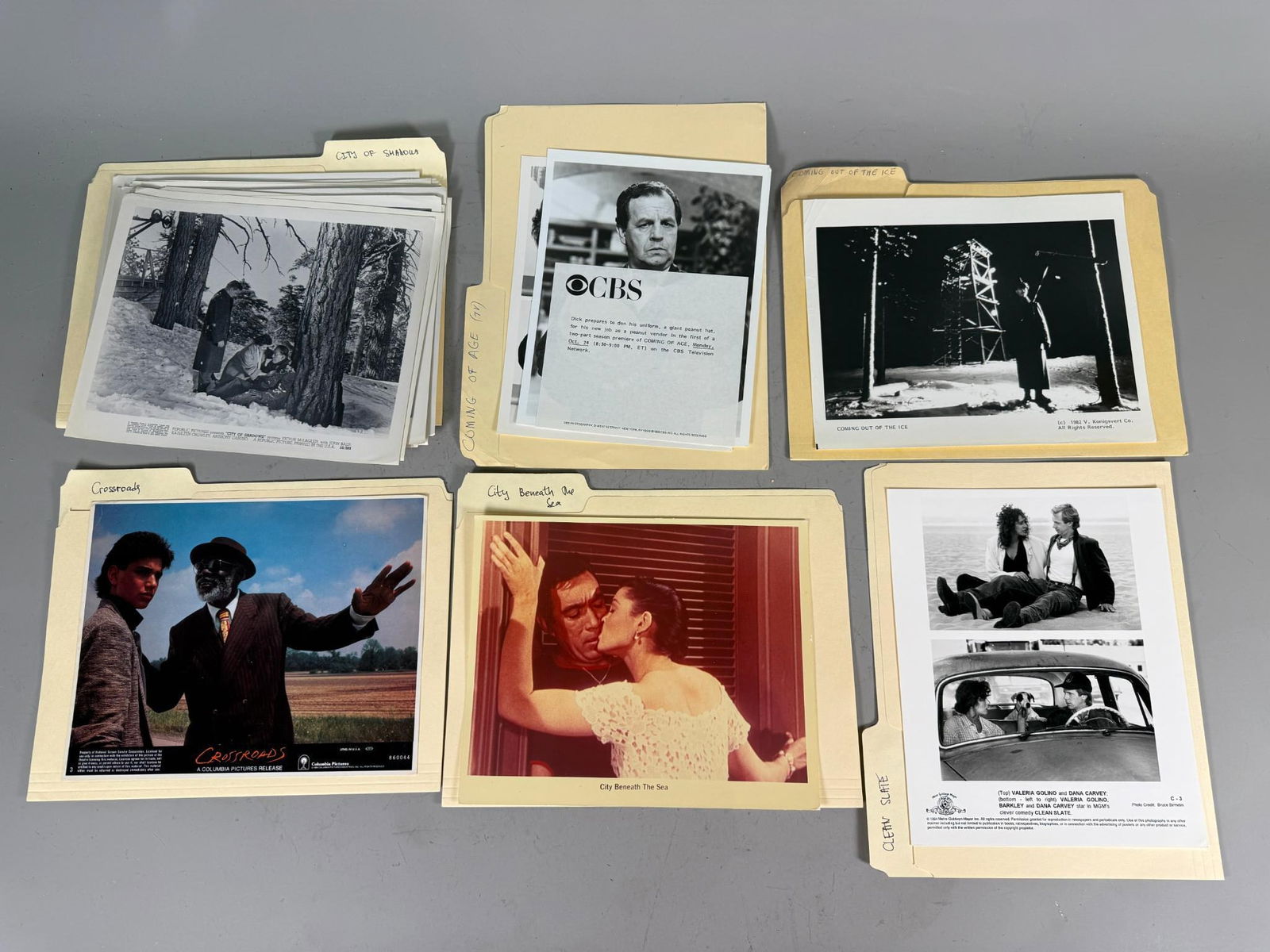A Collection of Vintage Film and Television Press Materials, 1980s-1990s: This collection comprises multiple vintage photographic prints and associated press materials, predominantly black and white with several color examples, systematically organized within individual man