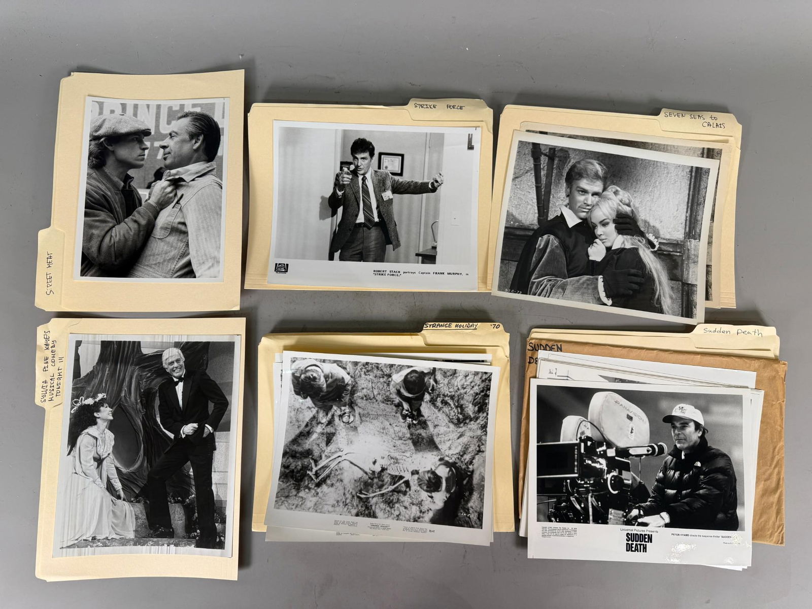A Collection of Vintage Mid-to-Late 20th Century Film and Television Publicity Stills: This collection comprises vintage black and white photographic prints, primarily film and television publicity stills or production photos, presented in assorted manila file folders. The images captur