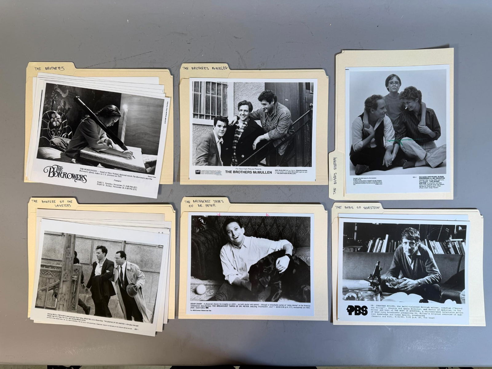 A Collection of Vintage Film and Television Press Photos, including 'The Brothers McMullen': This lot comprises a collection of vintage black and white photographic prints, primarily publicity stills or promotional photographs, organized within several manila file folders. The prints, likely