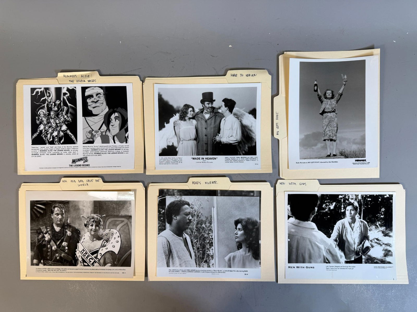 A group of Film and Television Promotional Stills, 1987-1997: A group of black and white photographic prints, likely promotional stills or press photos, each contained within a standard manila folder. The folders bear handwritten labels on their tabs, identifyin