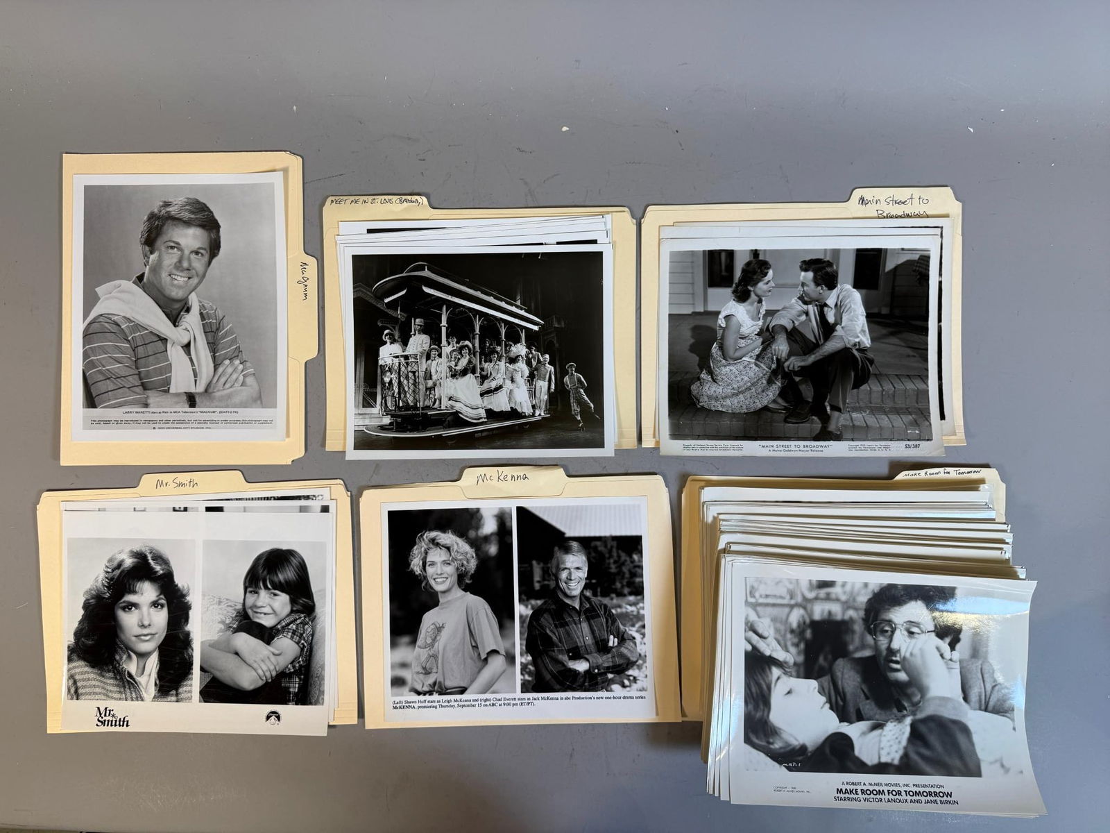 A Collection of Vintage Movie and Television Promotional Stills and Headshots: A collection of numerous black and white glossy photographic prints, primarily promotional stills and actor headshots, organized within several labeled manila folders. Titles identified from folder ta