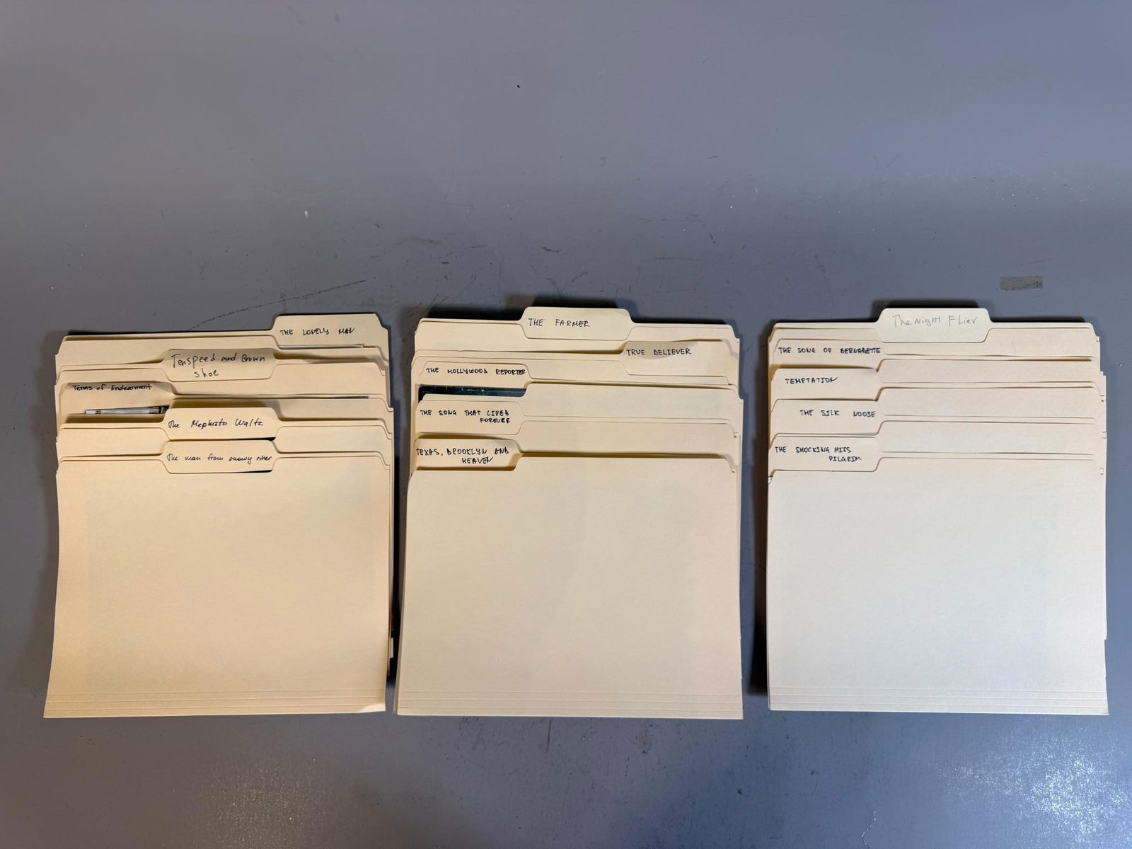 A Collection of Archival Film and Television Production Materials in Manila Folders, Mid-20th to: This collection comprises group of manila file folders, organized into group of rows, containing archival materials primarily focused on films and television productions. The folders are identified by