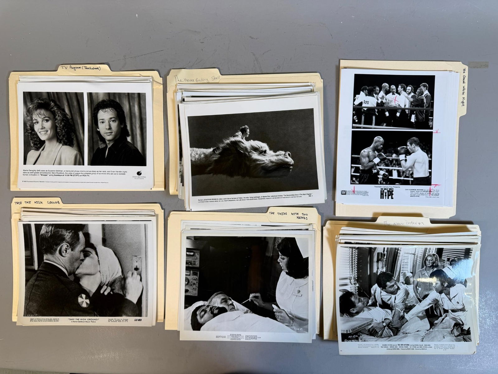 A Collection of Vintage Black and White Film and Television Publicity Stills, 1953-1996: A collection of approximately 50-70 vintage black and white photographic publicity stills and production photos, organized into group of manila file folders. The photographs, printed on standard gloss