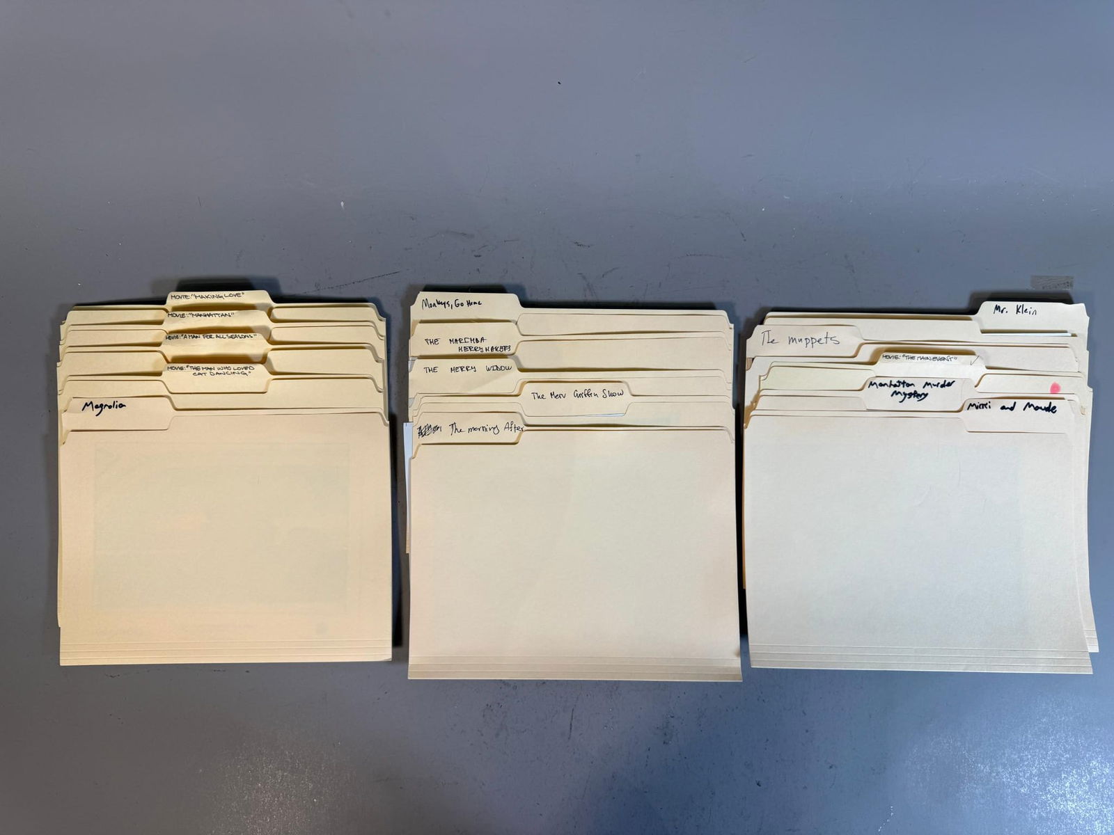 A Collection of Mid to Late 20th Century Film and Television Publicity Stills in Manila Folders: A collection of numerous black and white photographic prints, predominantly publicity stills or press photos from film and television productions, meticulously organized within tan manila folders. The