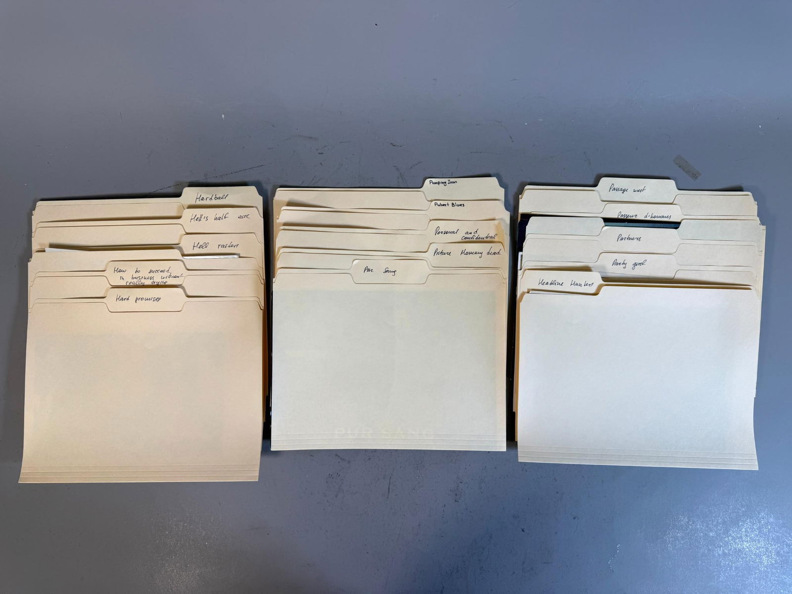 A Collection of Vintage Film and Television Production Stills and Archival Files: A collection comprising group of stacks of vintage manila file folders, many visibly labeled with handwritten titles such as "HAIR musical," "Pumping Iron," "Hardball," "Party girl," and "Pornography.