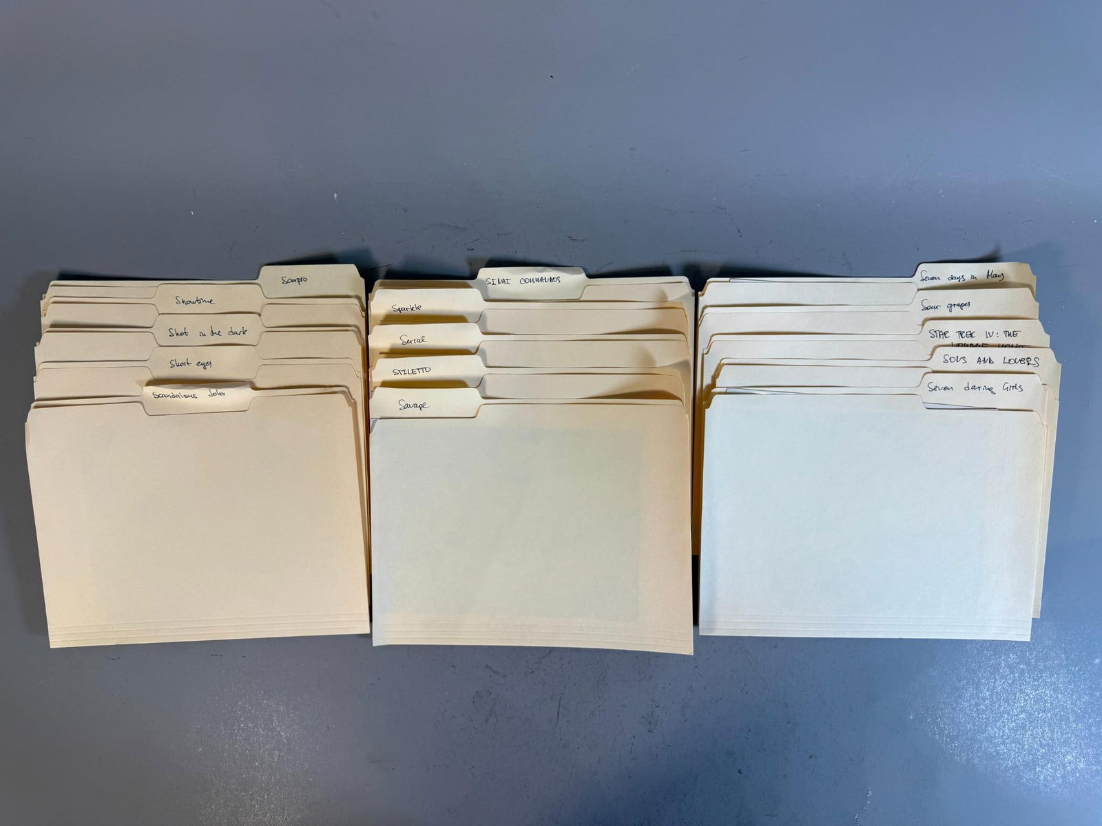 A Collection of Mid-Late 20th Century Film and Television Press Photographs in Manila Folders: A collection of black and white glossy photographic prints, characteristic of mid to late 20th-century cinema or television production, housed within group of organized stacks of standard manila file