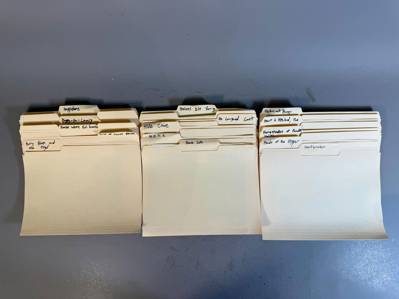 A Collection of Film and Television Press Stills and Promotional Materials: A collection of film and television press stills and promotional materials, primarily black and white but with some color examples, housed in group of rows of manila file folders. The folders are orga