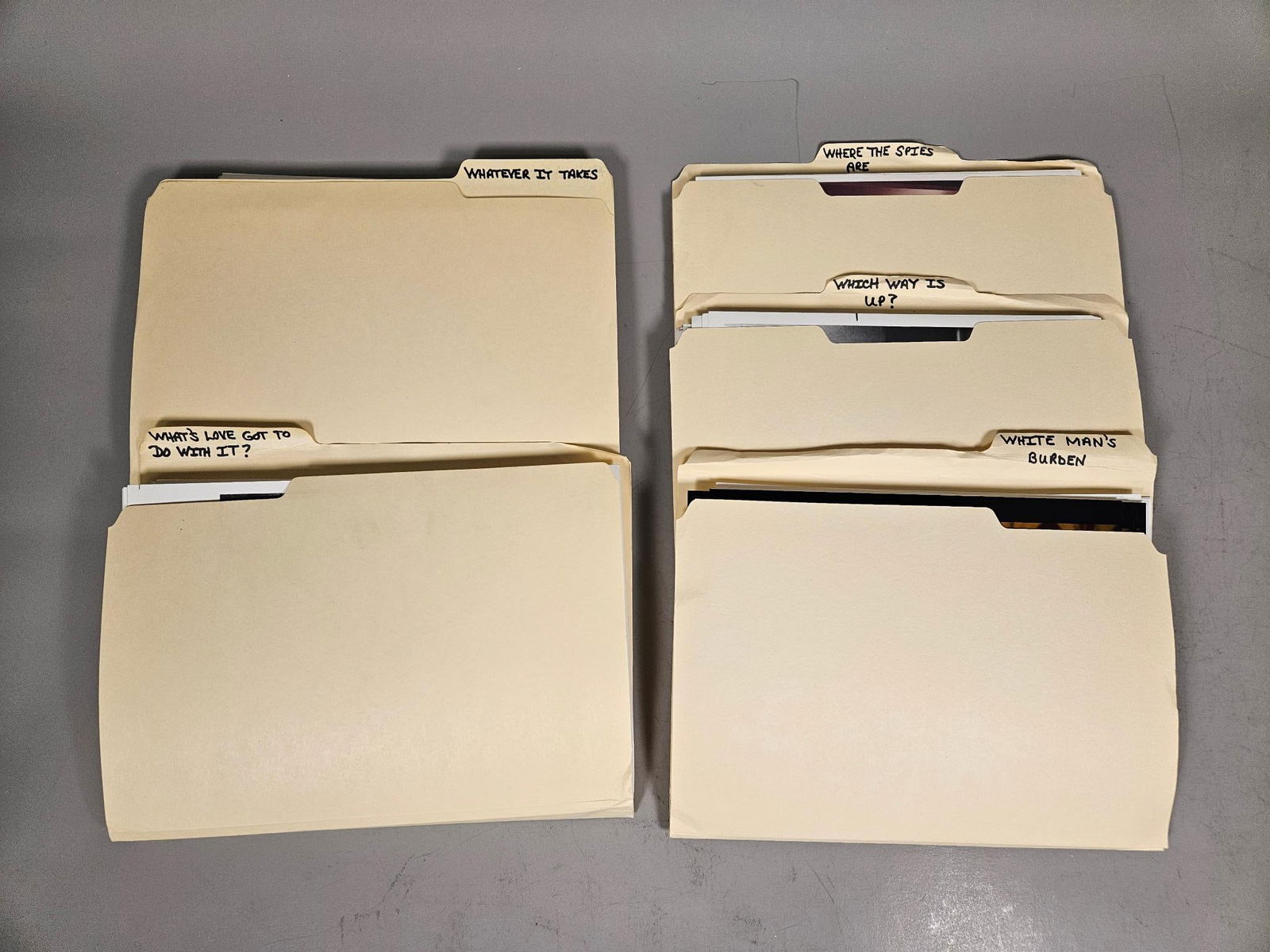 group of Folders of Film and Television Publicity Stills: This lot comprises group of standard tan cardstock file folders, each containing multiple photographic prints. The folders are distinctly labeled on their tabs in black marker with phrases that appear