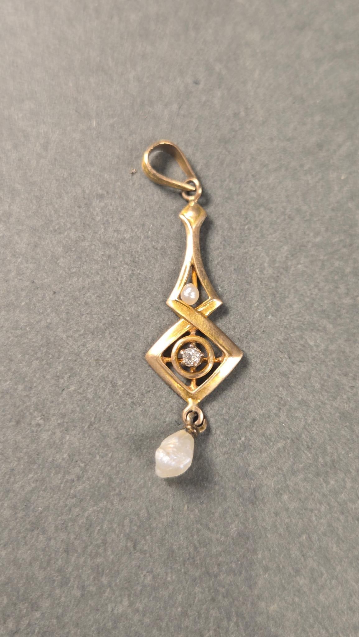 Antique 10k Gold Diamond and Pearl Pendant: An antique 10k gold pendant, featuring a geometrically stylized elongated form. The pendant is crafted from 10k gold, confirmed by a '10K' stamp on its reverse. It showcases a central rhombus element