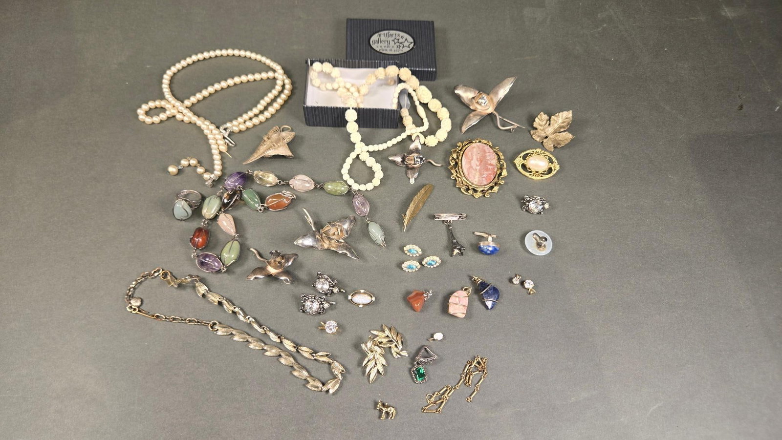 A Group Lot of Vintage Mid-to-Late 20th Century Costume Jewelry: A group lot of vintage costume jewelry, consistent with mid-to-late 20th-century aesthetics. The collection includes necklaces featuring simulated pearls, carved floral beads, and multi-stone elements