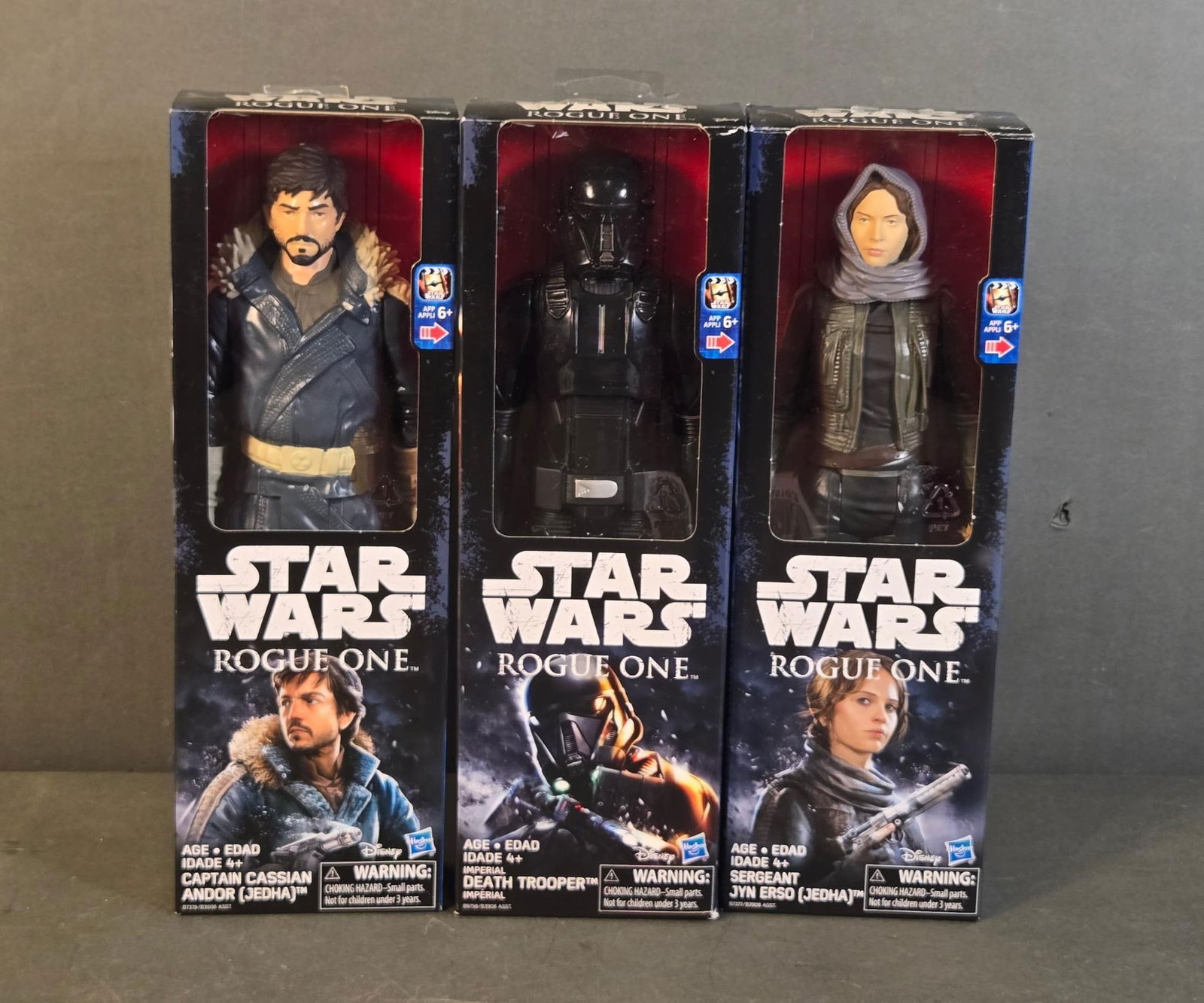 Three Hasbro Star Wars Rogue One 12-Inch Action Figures: Captain Cassian Andor, Death Trooper, and: Three Hasbro Star Wars Rogue One 12-Inch Action Figures, comprising Captain Cassian Andor (Jedha), a Death Trooper™, and Jyn Erso (Jedha). Each figure is individually housed in its original factory-
