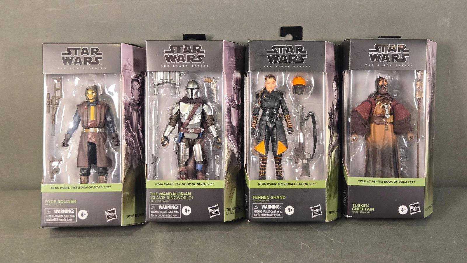 A Group of Four Star Wars The Black Series Action Figures from The Book of Boba Fett: A group of four contemporary "STAR WARS THE BLACK SERIES" action figures from the "STAR WARS: THE BOOK OF BOBA FETT" collection, manufactured by Hasbro. Each figure is individually housed in its origi