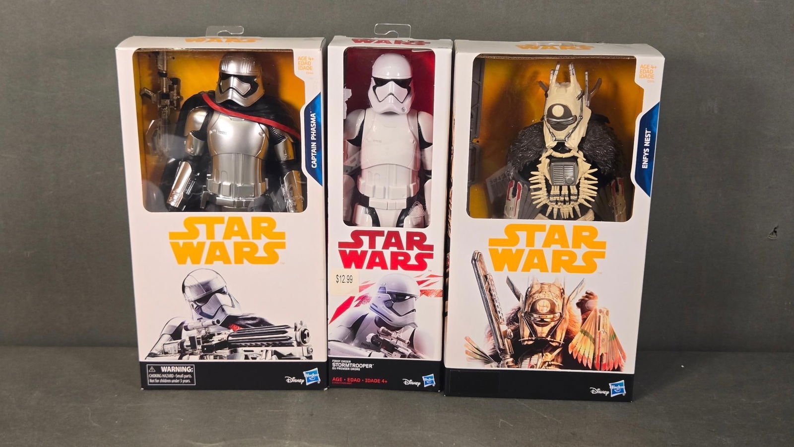 Three Hasbro Star Wars 12-Inch Action Figures: Captain Phasma, First Order Stormtrooper, and Enfys: A group of three Hasbro Star Wars 12-inch action figures, comprising Captain Phasma from "The Last Jedi," a First Order Stormtrooper, and Enfys Nest. The modern plastic figures are housed within indiv