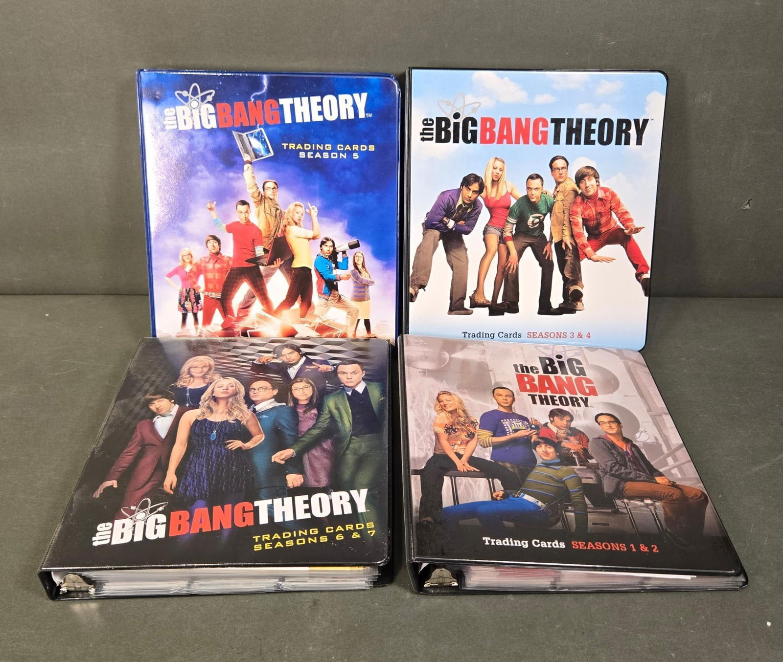 A Set of Four Cryptozoic 'The Big Bang Theory' Trading Card Binders with Autograph and Wardrobe: A set of four Cryptozoic 'The Big Bang Theory' entertainment trading card binders. Each plastic 3-ring binder is themed around the popular television series 'The Big Bang Theory,' with distinct covers