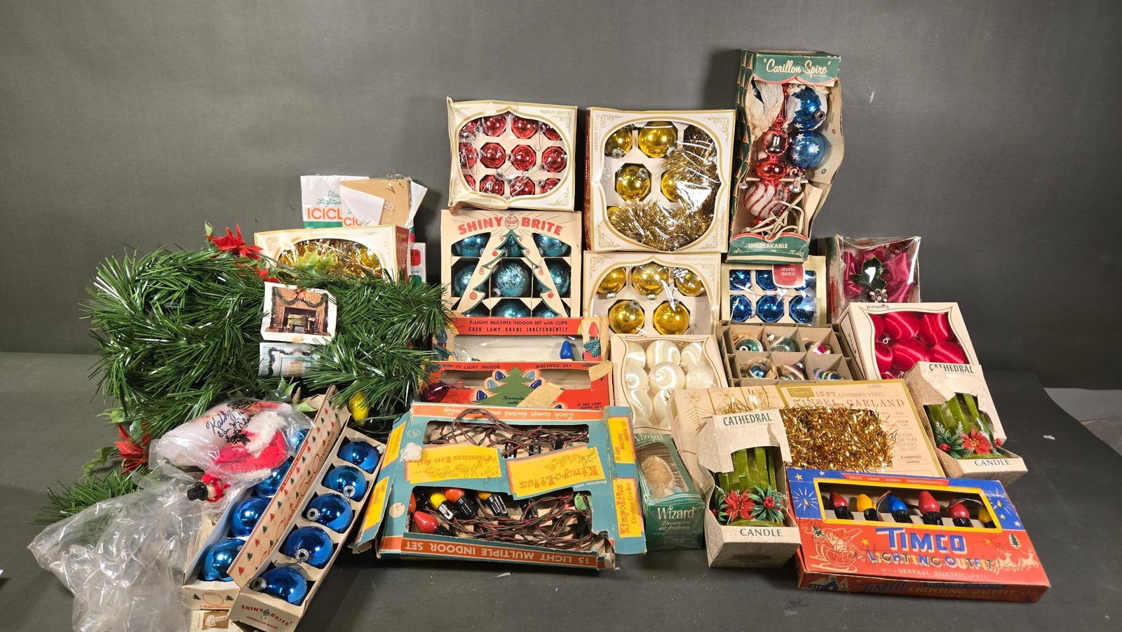 A Collection of Vintage Shiny Brite and Other Mid-20th Century Christmas Decorations: A large collection of vintage mid-20th century Christmas decorations, prominently featuring multiple sets of Shiny Brite glass Christmas tree ornaments, including red, gold, and blue spherical ornamen