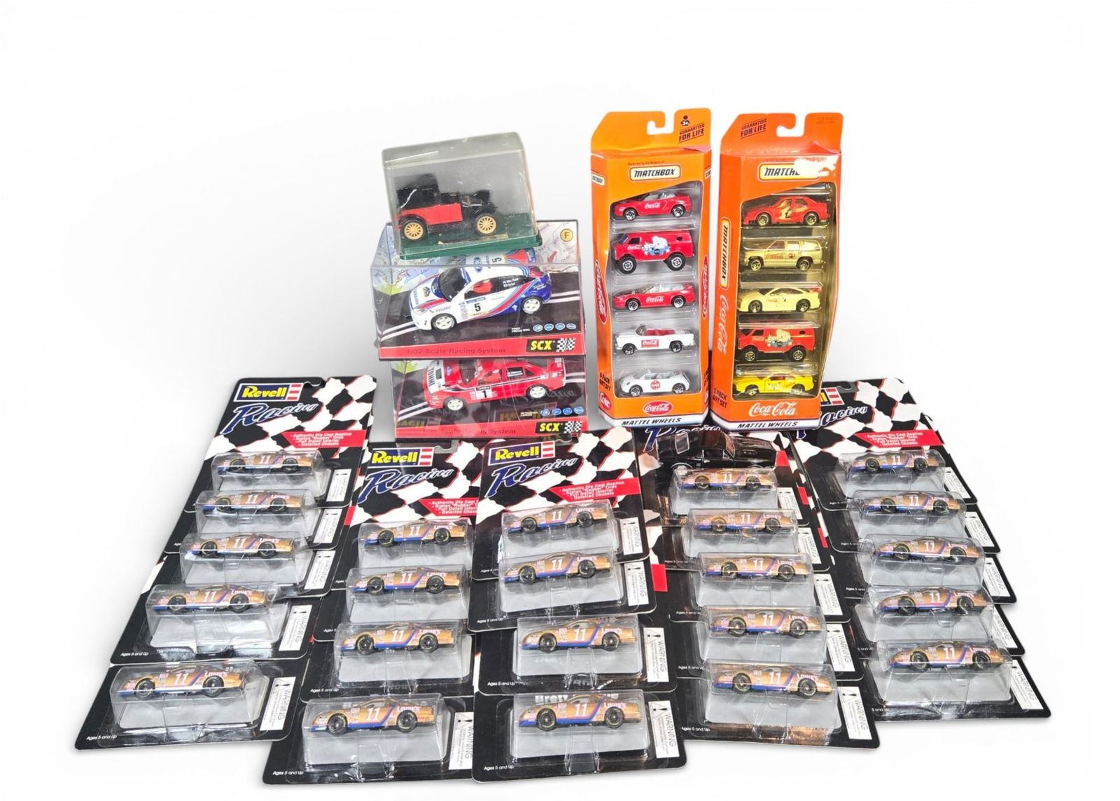 A group of Revell, Matchbox, SCX, and ERTL Racing Die-Cast and Slot Cars: The collection consists of die-cast model vehicles and slot cars from various manufacturers, primarily focused on racing themes. The majority of the lot is comprised of individually carded Revell Raci