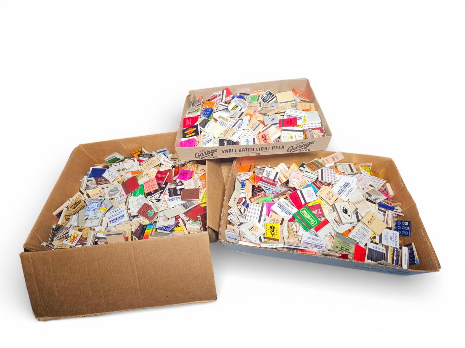 Collection of Vintage and Contemporary Advertising Matchbooks: Collection of vintage and contemporary advertising matchbooks and matchboxes. The lot is contained within open corrugated cardboard boxes. The collection consists of thousands of individual matchbooks