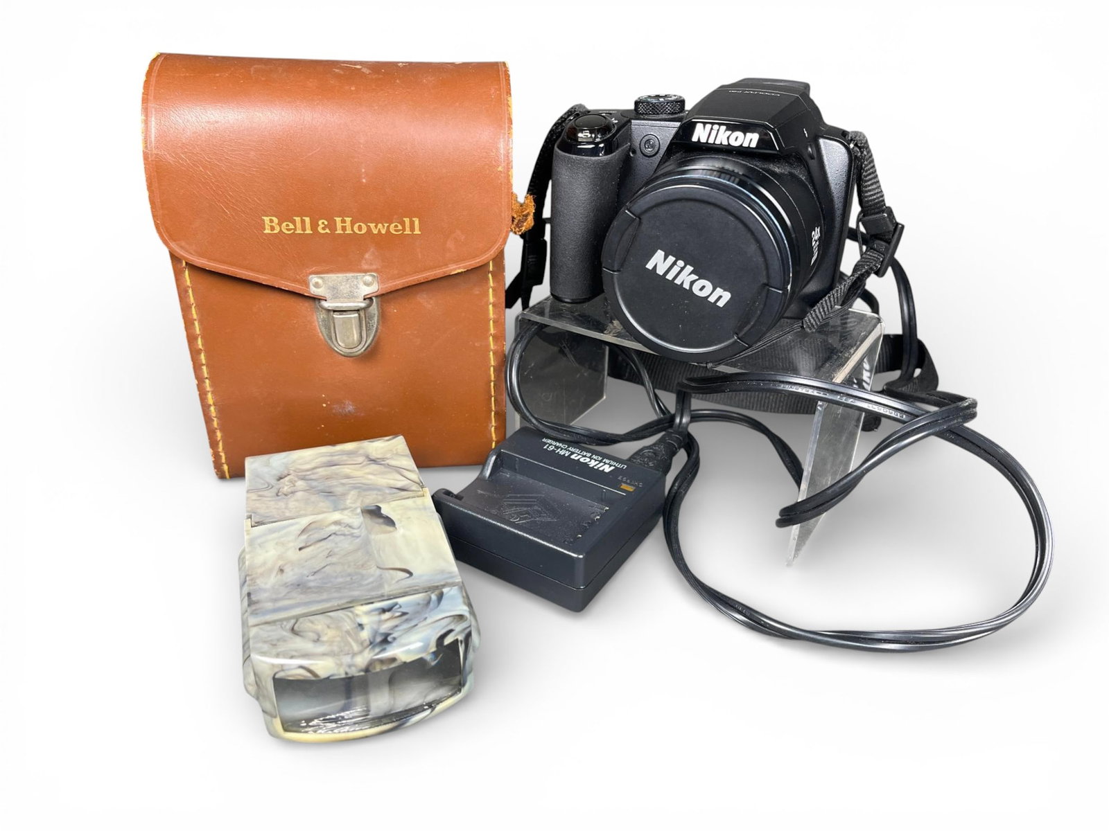 Bell & Howell Model 252 8mm Movie Camera and Nikon COOLPIX P90 Digital Camera Lot: A group of photographic and cinematic items centered on distinct camera systems. The vintage system includes a Bell & Howell Model 252 8mm movie camera, constructed of textured tan and brown metal. Th