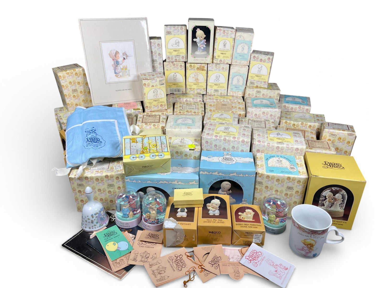 A group of Precious Moments Bisque Porcelain Figurines, Ornaments, and Ephemera by Enesco: Collection consists of items/lots of Precious Moments branded merchandise, primarily manufactured by Enesco, dating largely to the 1980s as indicated by visible Collector's Club symbols (e.g., 1983, 1