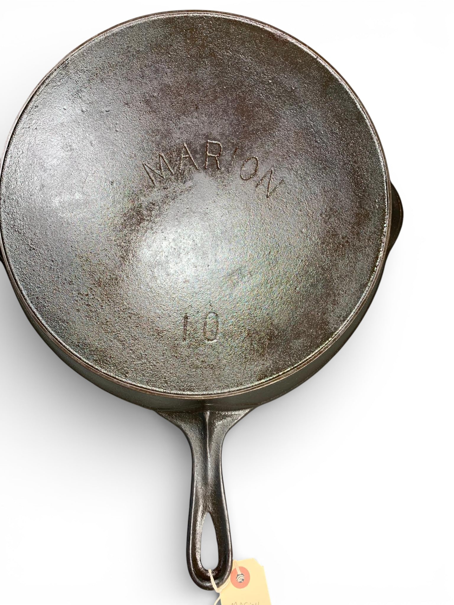 Vintage Marion Cast Iron Skillet Size 10: A vintage cast iron skillet, size number 10, manufactured by Marion. The skillet features a continuous pour spout and a long, integral handle terminating in a teardrop-shaped hanging hole. The