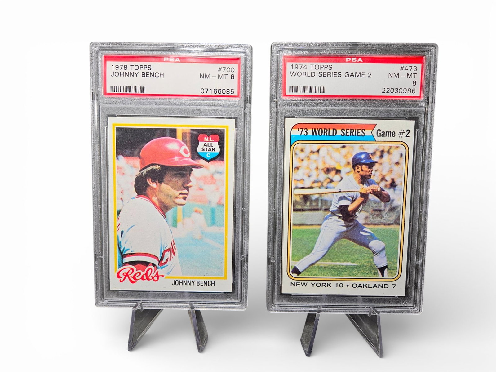 A group of Graded Topps Baseball Cards: 1978 Johnny Bench and 1974 World Series Game #473: A group of professionally graded baseball trading cards manufactured by Topps. The collection consists of cards, both encapsulated in standard tamper-evident PSA plastic holders and graded Near Mint-M