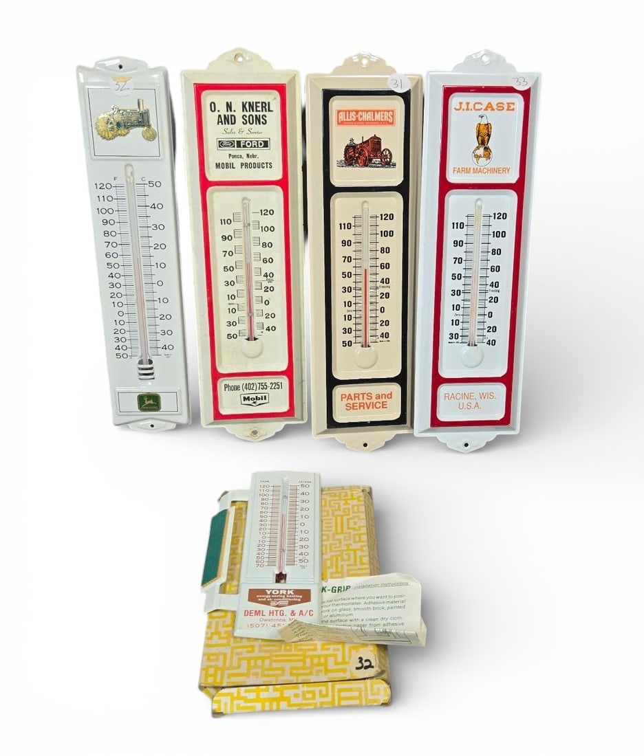 A group of Vintage Advertising Wall Thermometers for Farm Machinery and HVAC: A group of advertising thermometers. items are vintage wall thermometers constructed of enameled metal, featuring dual Fahrenheit and Celsius scales. These pieces advertise classic farm machinery and