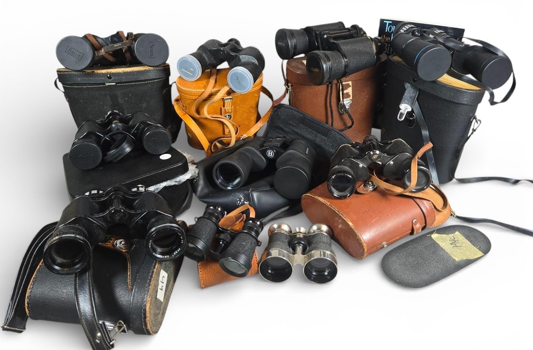 Vintage and Modern Binoculars with Cases and Guidebook: Collection of items of optical equipment and accessories, comprising binoculars, associated carrying cases or bags, and a instructional guidebook. The binoculars are primarily porro prism types