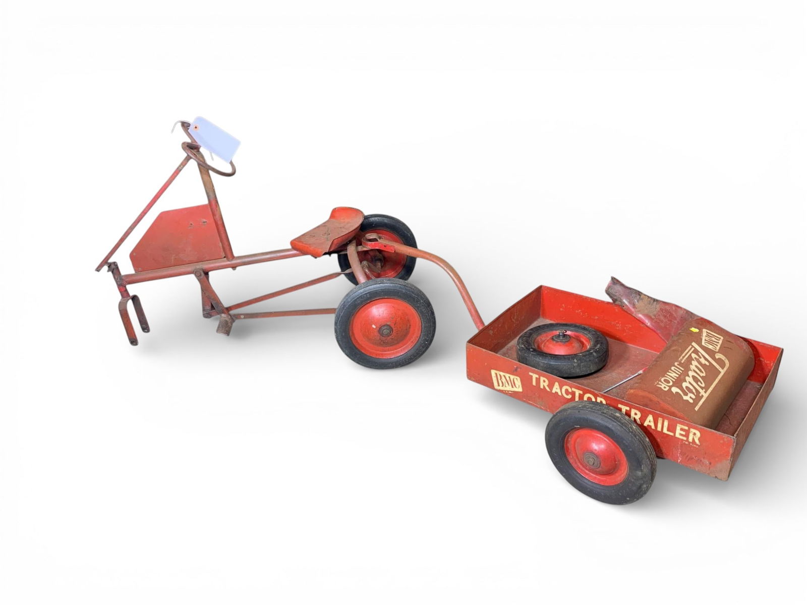 BMC Tractor Junior Pedal Tractor Components: BMC (Binghamton Metal Company) Tractor Junior pedal tractor and trailer set, constructed of pressed steel and tubular metal with rubber tires on red metal hubs. The lot includes the main tractor frame