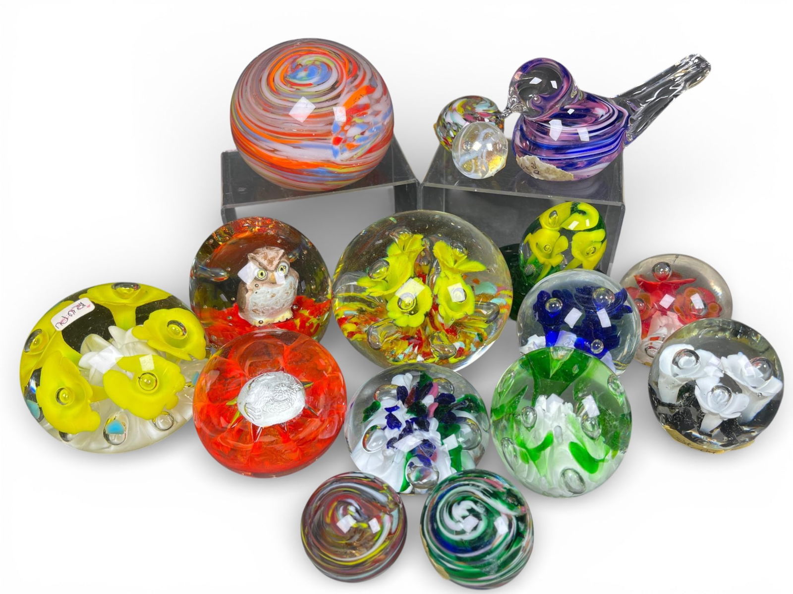 A group of St. Clair Studio Art Glass Paperweights and Figurines, Signed Jim Davis and Jim Hopper: A group of pieces of American studio art glass, consisting primarily of blown glass paperweights, a bird-form figurine, and a floral egg on a separate base. The paperweights feature internal designs,