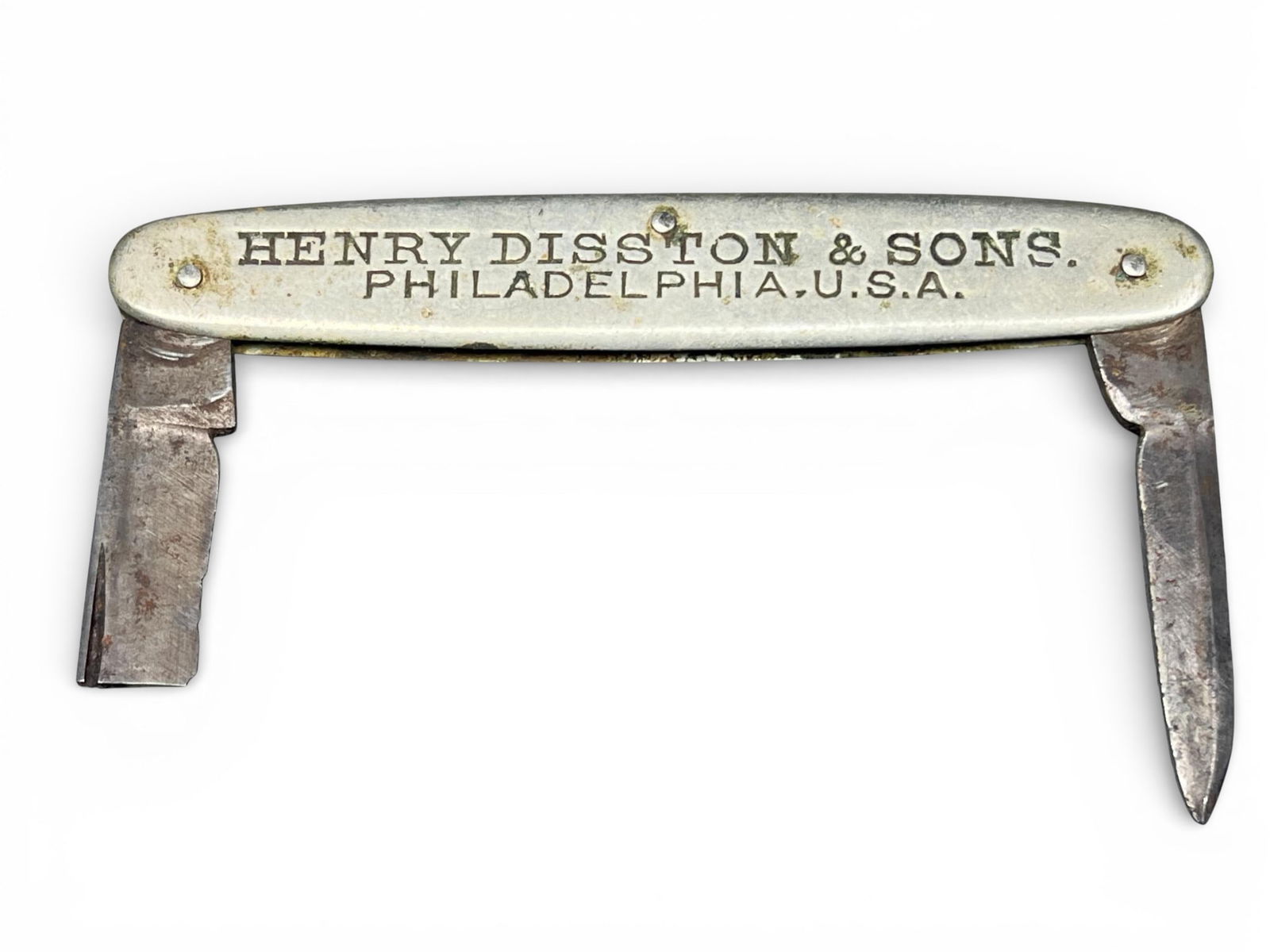 Vintage Henry Disston & Sons Advertising Pocket Knife Made From Saw Steel: A vintage advertising pocket knife, commonly known as a jackknife, featuring rounded metal scales and folding steel blades. The item was manufactured by Henry Disston & Sons, a prominent Philadelphia