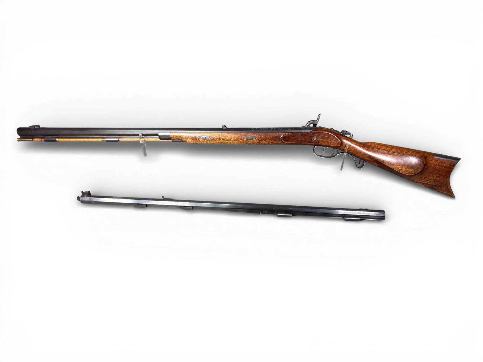 Lyman Great Plains Muzzleloading Rifle + Extra Barrel: A Lyman Great Plains Rifle percussion muzzleloader and an additional interchangeable barrel. The rifle is constructed with a dark-stained wood stock and a blued octagonal barrel. The rifle barrel is m