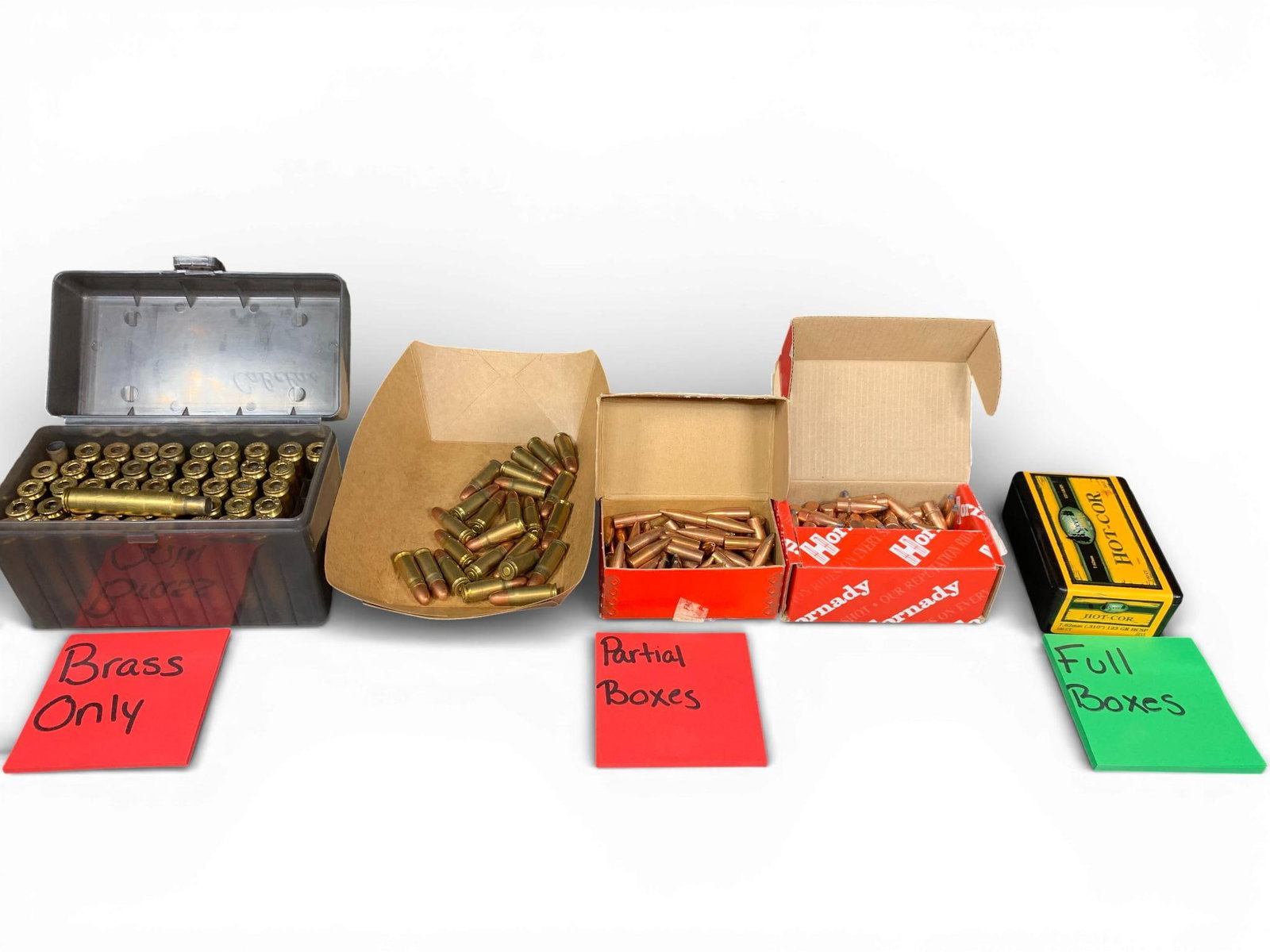 A Collection of Ammunition Components and Cartridges: This collection of reloading components and ammunition includes spent brass casings, projectiles for handloading, and loose cartridges. The spent brass consists of .30-06 Springfield casings with head