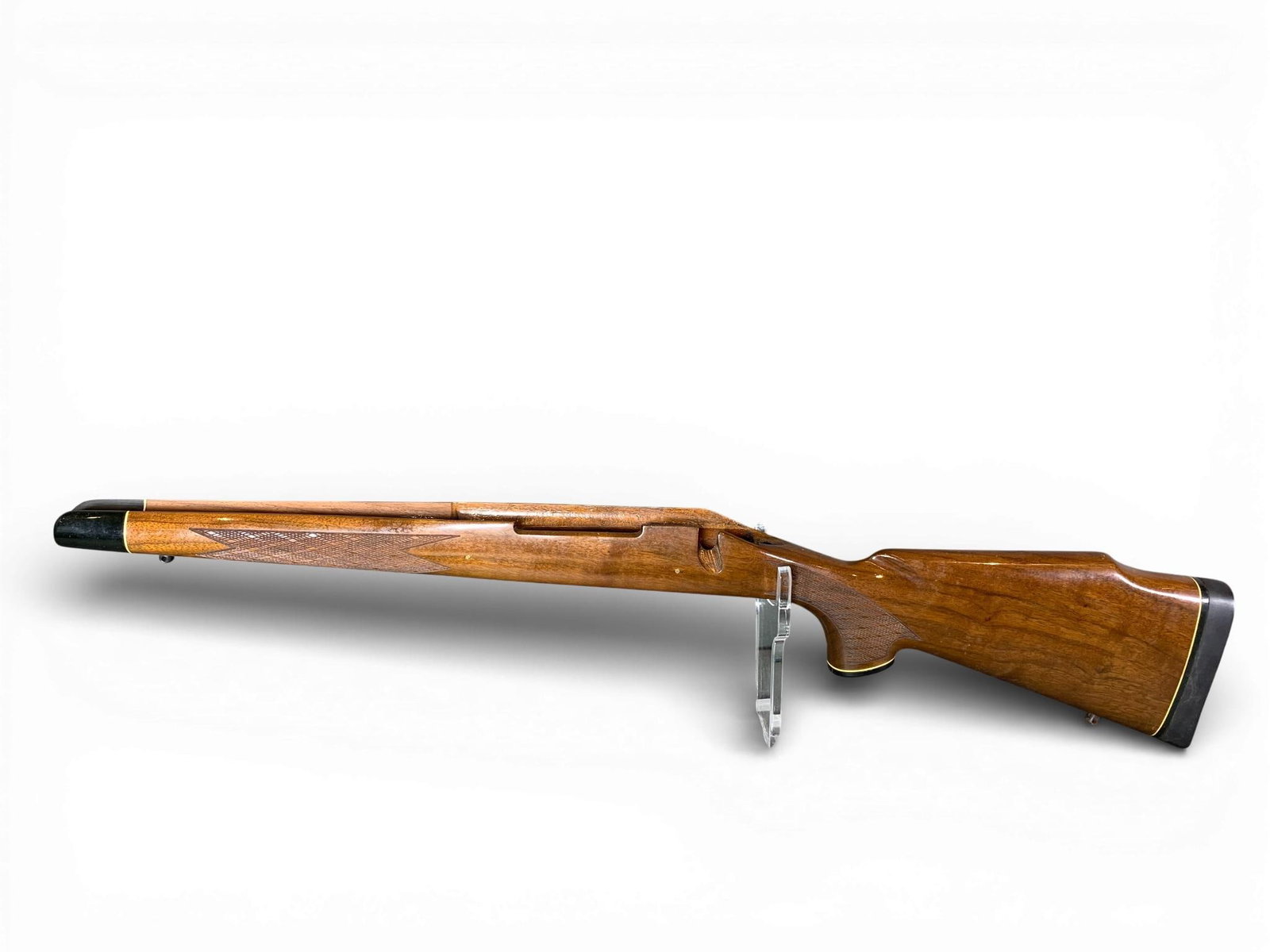 A Bell and Carlson Carbelite Synthetic Rifle Stock: A Bell and Carlson Carbelite synthetic sporting rifle stock featuring a high-gloss wood-grain finish. This one-piece stock is designed with a Monte Carlo style comb and an integrated cheekpiece. The