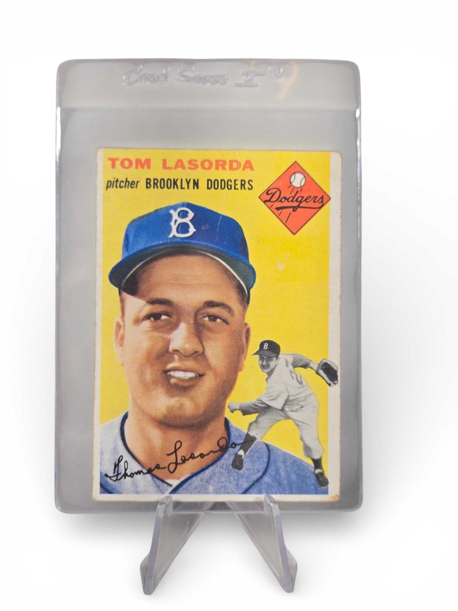 1954 Topps Tom Lasorda: Crease at the top down to B on hat. Burns in-house shipping is available. Pick up is Saturday, Feb. 28 from 10 am to 4 pm at our gallery in Lancaster, Ohio 43130 or we will provide in-house shipping f
