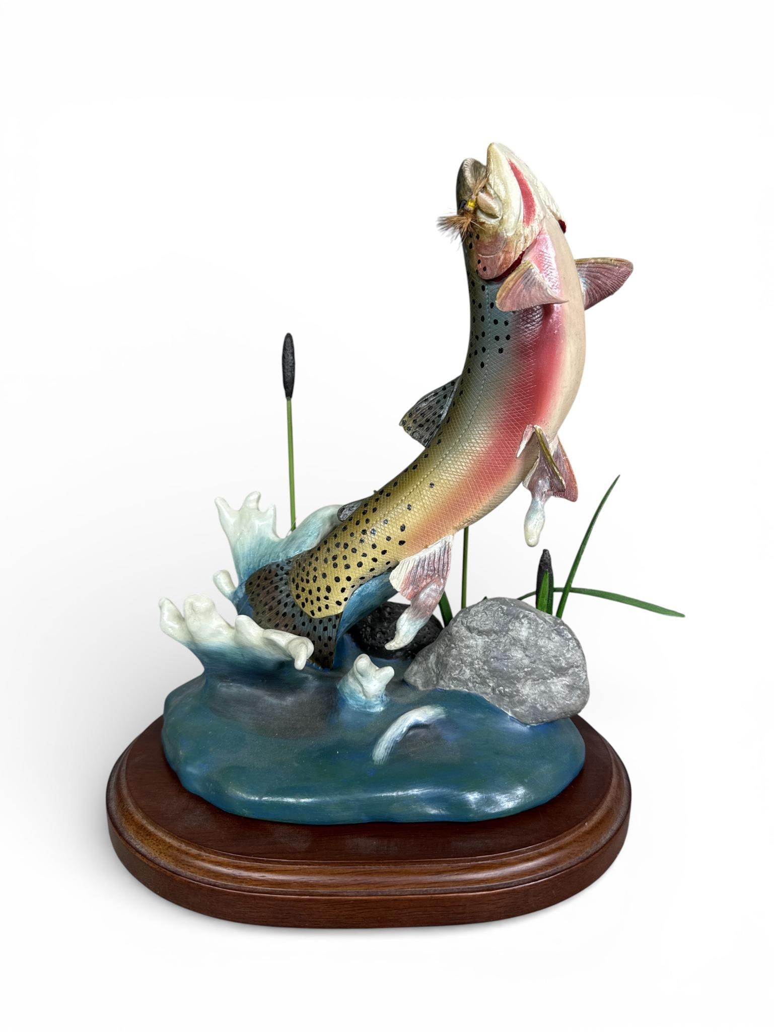 Franz Dutzler for Danbury Mint Rainbow Rising Trout Sculpture: This wildlife sculpture, titled Rainbow Rising, was designed by artist Franz Dutzler for the Danbury Mint. The piece depicts a rainbow trout mid-leap from a splashing water base, featuring a fly-fishi