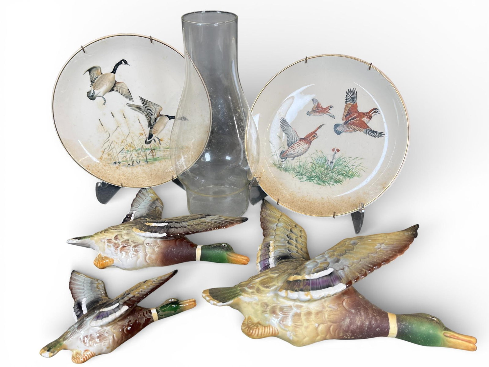 An Assortment of Vintage Avian-Themed Decorative Items including Lefton Mallard Plaques and Salem: This collection of vintage decorative items features avian motifs and includes ceramic wall plaques, decorative plates, and a glass chimney. The mallard duck wall plaques are crafted from glazed ceram
