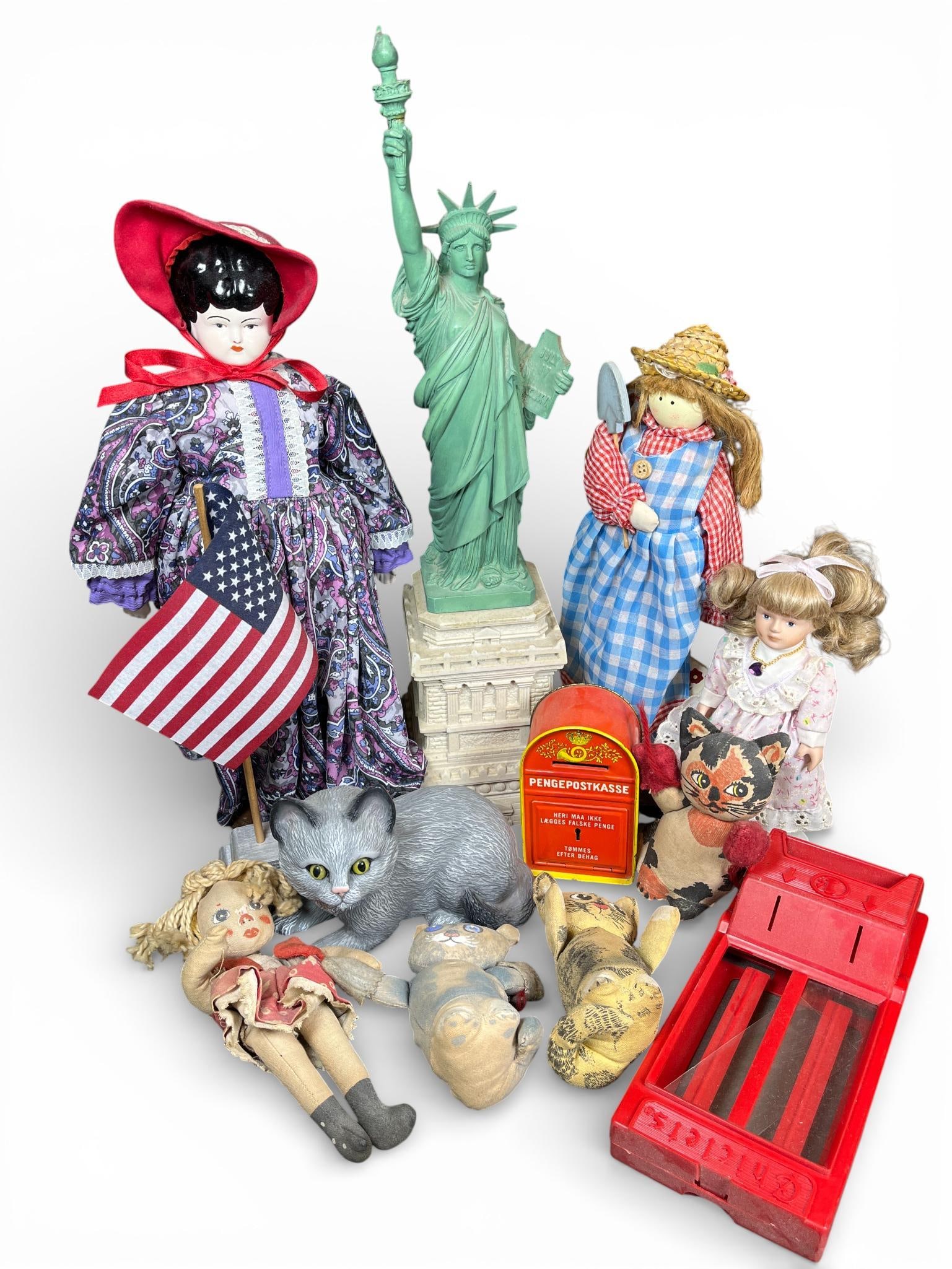 An Assortment of Vintage Dolls, Toys, and Souvenir Collectibles: This collection comprises a diverse range of vintage toys and promotional items. Included are several dolls, notably a Russ Berrie & Co. porcelain and cloth doll from the Amethyst series and a doll di