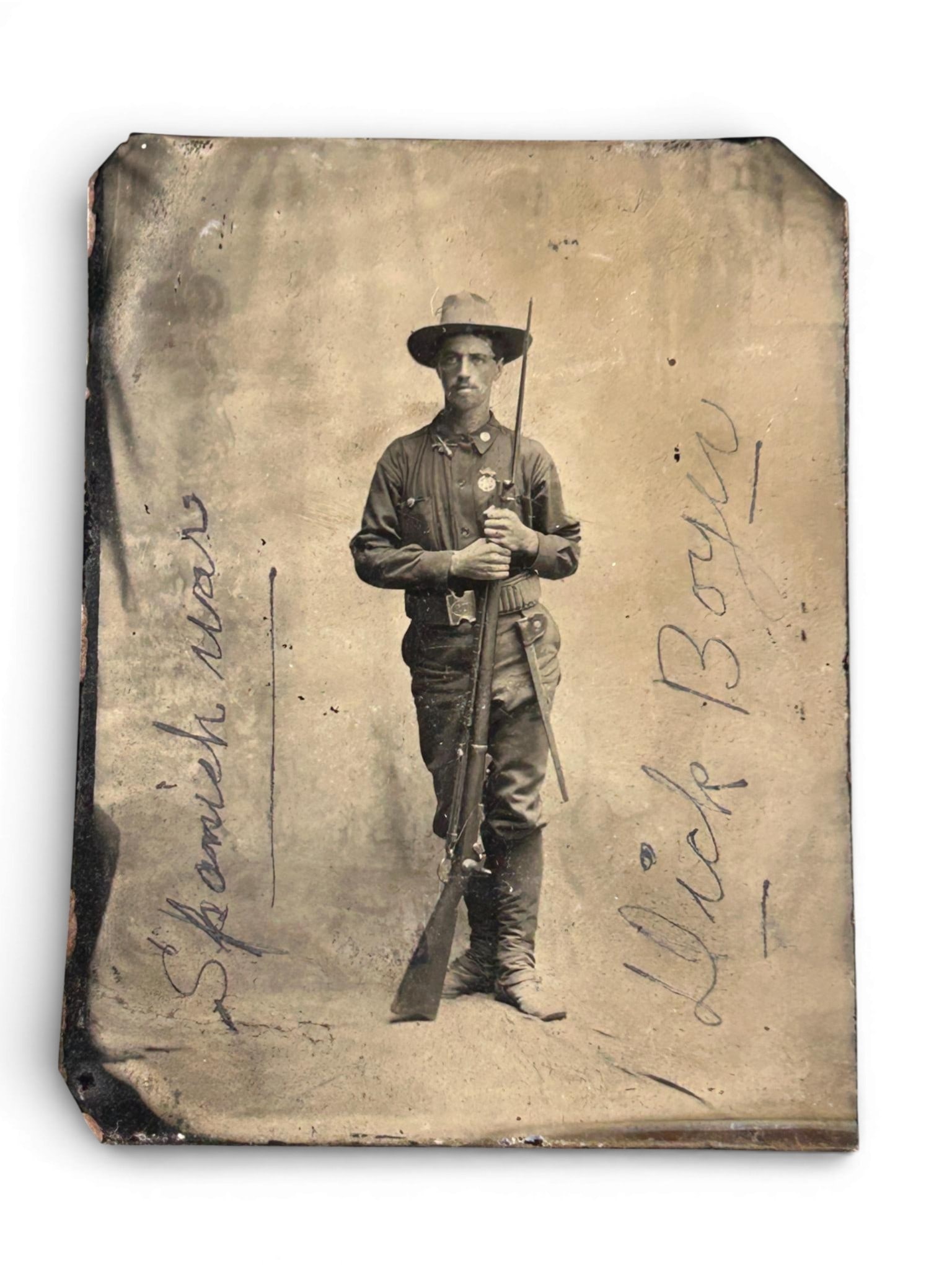 Identified Tintype - Spanish American War soldier: Span-Am War tintype featuring a soldier holding a 45-70 rifle with fixed bayonet. The scabbard is visible on his dark (blue) 45-70 looped cartridge belt. There is a medal affixed to his campaign blous