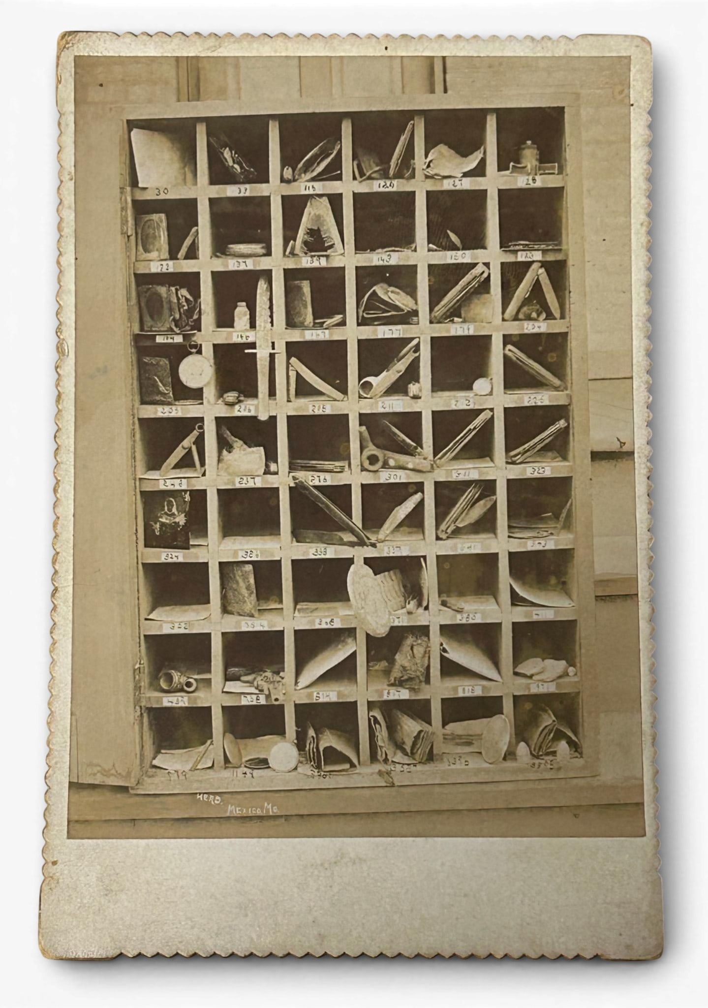 Post Civil War Cabinet Card Photograph - Relics from the Pockets of Soldiers Buried at Shiloh.: Cabinet Card featuring relics taken from soldiers' pockets at the Battle of Shiloh when they were interred in the National Cemetery. This image shows a large frame with cubbyholes, each numbered and c