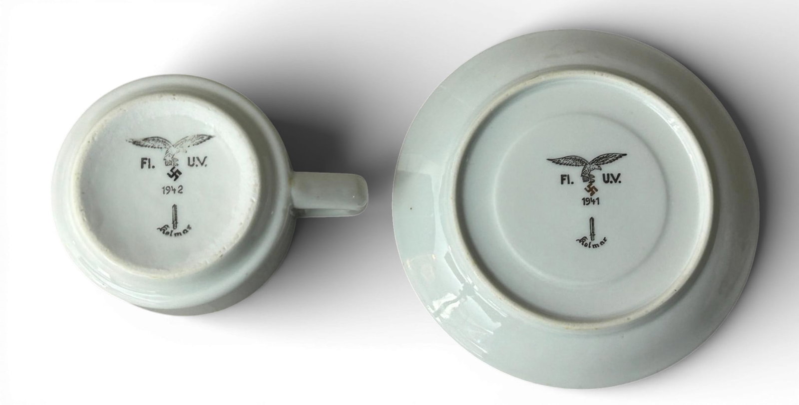 WWII Nazi German Luftwaffe 1942 Porcelain Coffee Cup & 1941 Saucer by Kolmar: World War II Luftwaffe porcelain 1942 coffee cup and 1941 saucer both made by Kolmar with maker's markings on the underside. Both pieces are plain on the obverse while the underside is marked with a L