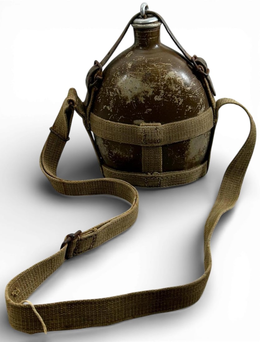 WWII Japanese Identified TYpe 94 Canteen & Harness: Japanese WWII Army Military Combat Type 94 Canteen with Harness. . Includes the tan canvas carrying strap. Has a small piece of leather strap that holds the stopper in place. The reverse side is named
