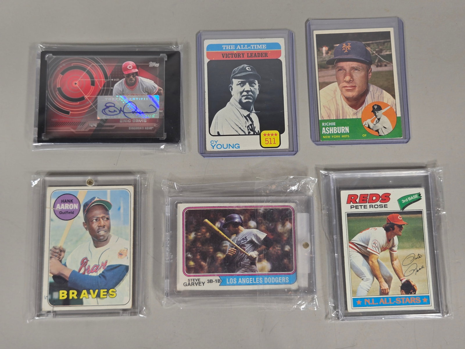 A Collection of Vintage and Modern Topps Baseball Cards Including 1974 Topps Steve Garvey #575: A collection of printed cardstock baseball cards produced by Topps, featuring players from various eras of Major League Baseball. The group includes a 1974 Topps Steve Garvey #575, a 1969 Topps Hank A