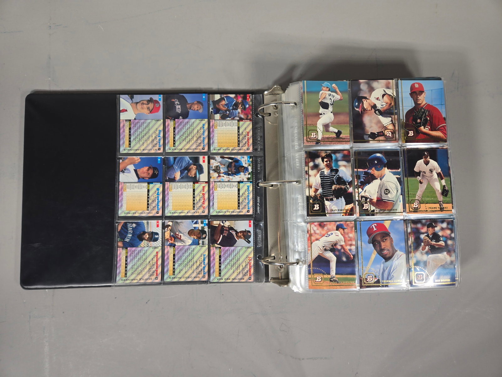 A Collection of Bowman Baseball Cards, Mid-1990s: A collection of Bowman brand Major League Baseball cards dating from the mid-1990s. The items are housed in a black three-ring binder with clear plastic nine-pocket sleeves. The cards feature a styliz
