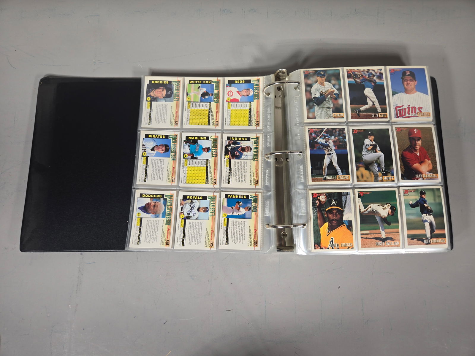 A Complete Set of 1993 Bowman Baseball Trading Cards: This assembly consists of a complete set of 1993 Bowman baseball trading cards presented in a black three-ring binder. The cards are secured within clear plastic multi-pocket protective pages. The set
