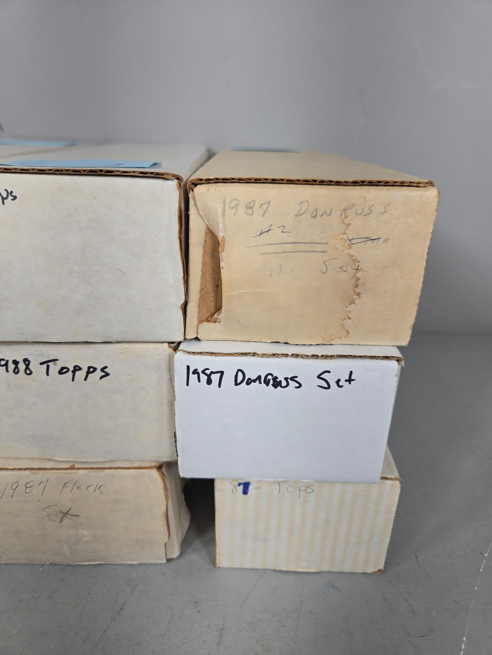 A Collection of Topps, Donruss, and Fleer Baseball Card Sets: A collection of baseball cards and complete sets from the late 1980s and early 1990s. The group includes various brands such as Topps, Donruss, and Fleer, with multiple boxes labeled as complete sets 