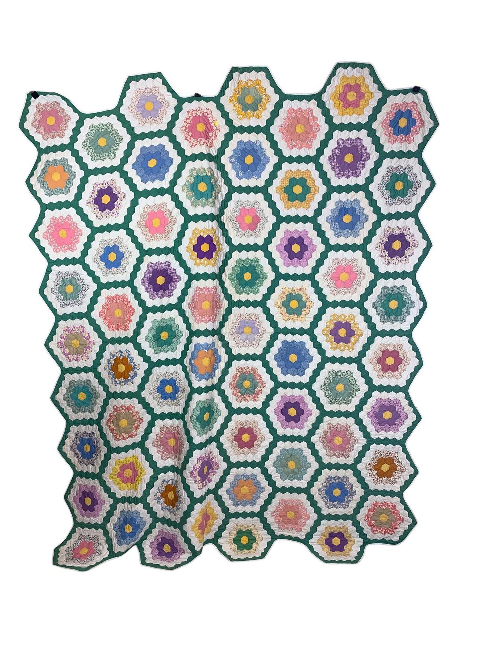 Handmade Cotton Patchwork Quilt, Grandmother's Flower Garden Pattern with Scalloped Edge: A vintage handmade cotton patchwork quilt featuring the traditional Grandmother's Flower Garden pattern. The decorative top is composed of numerous multi-colored hexagonal floral medallions, each feat