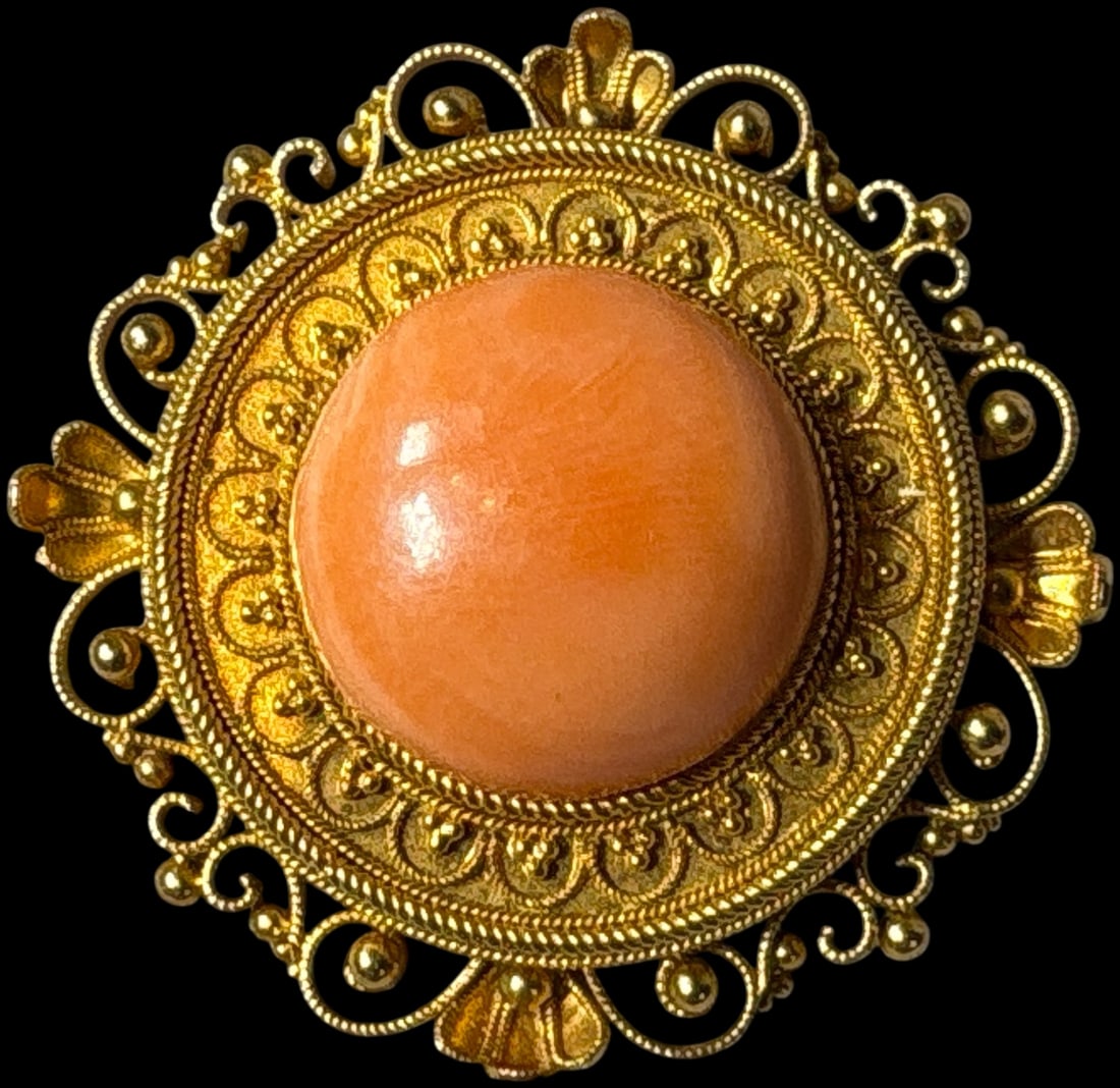 18K Yellow Gold and Coral Filigree Brooch Marked EOA: A circular 18 karat yellow gold filigree brooch featuring a central coral-colored cabochon, marked EOA K18, weighing 7.05 grams total and measuring 1.05 inches wide. Burns in-house shipping is availab