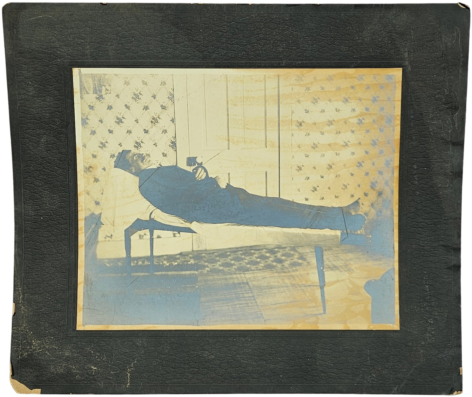 Antique Post-Mortem Albumen Print Portrait of a Man: This antique photograph is an albumen print depicting a post-mortem portrait of a man, a genre of photography common in the Victorian era used to memorialize the deceased. The subject is dressed in a 