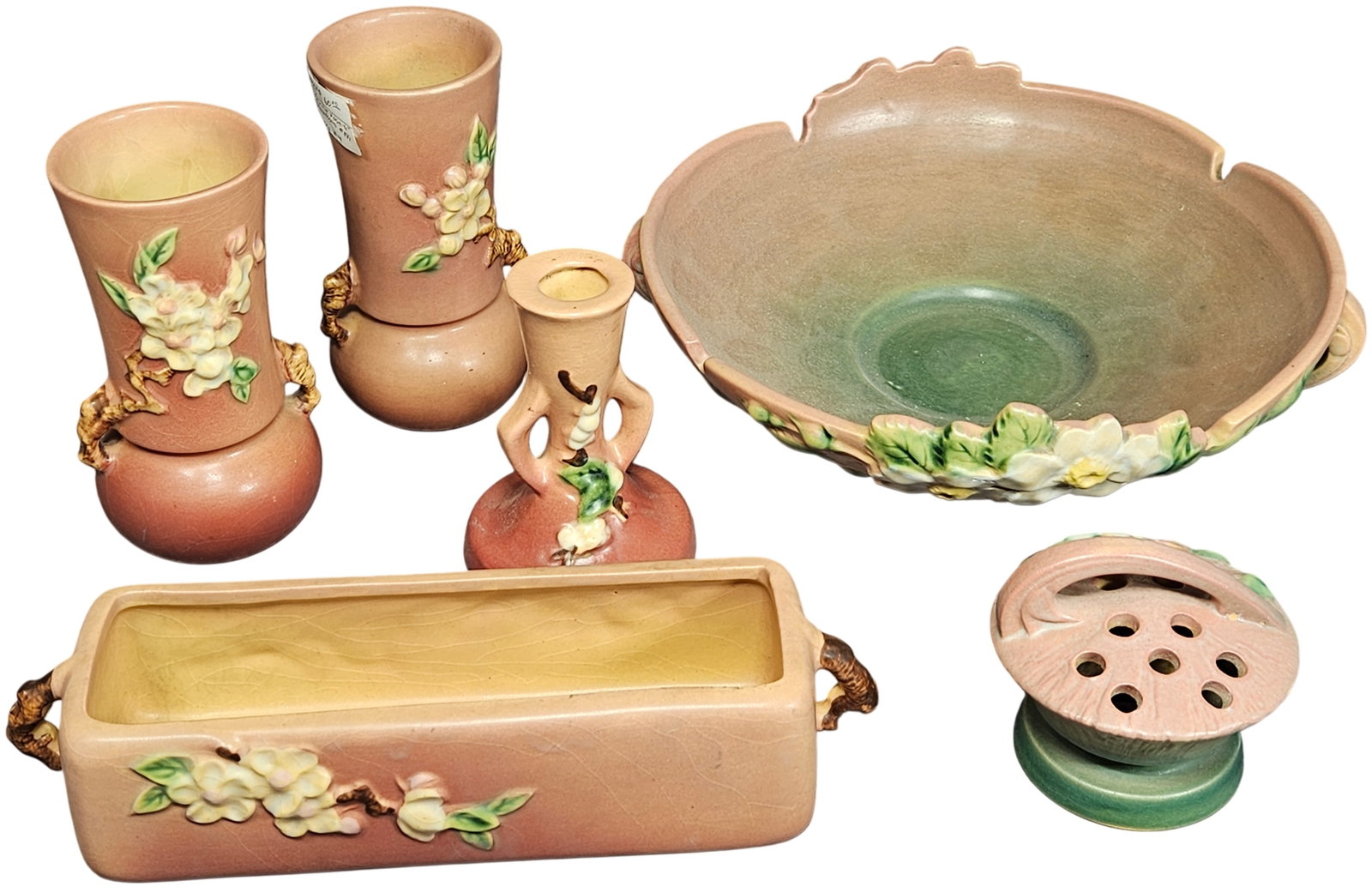 A 6-Piece Collection of Roseville Apple Blossom Art Pottery: This group of American art pottery consists of six pieces in the Apple Blossom pattern by Roseville Pottery, which was introduced in 1948. The earthenware items feature a matte glaze in a coral pink a