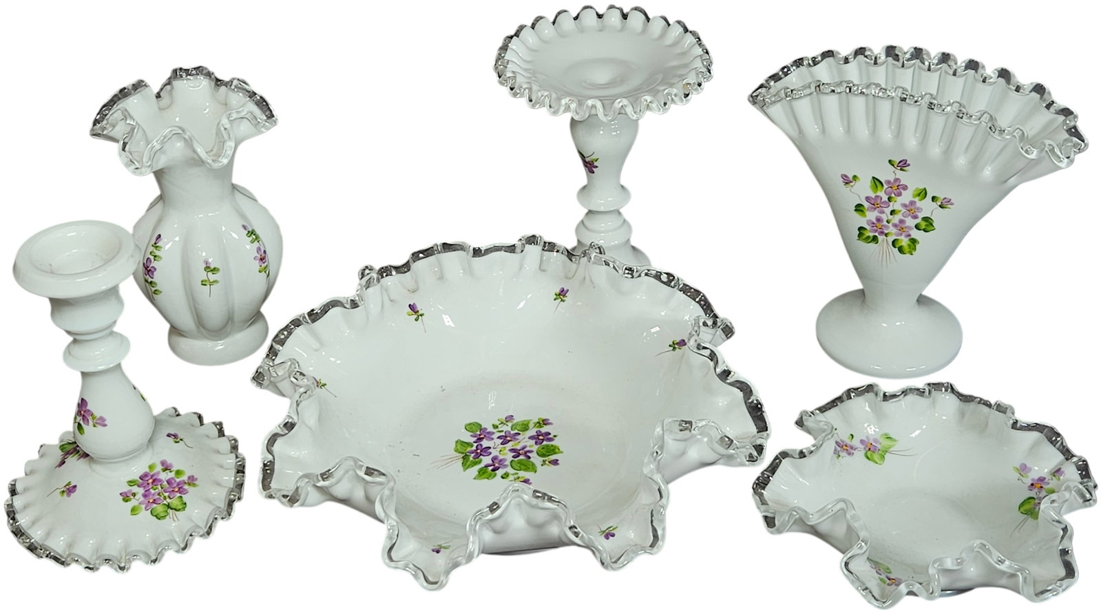 A set of six Fenton Silver Crest Violets in the Snow hand painted milk glass items: A set of six vintage Fenton Art Glass items in the Violets in the Snow pattern. The collection is crafted from opaque white milk glass featuring clear glass ruffled Silver Crest rims. Each piece is de